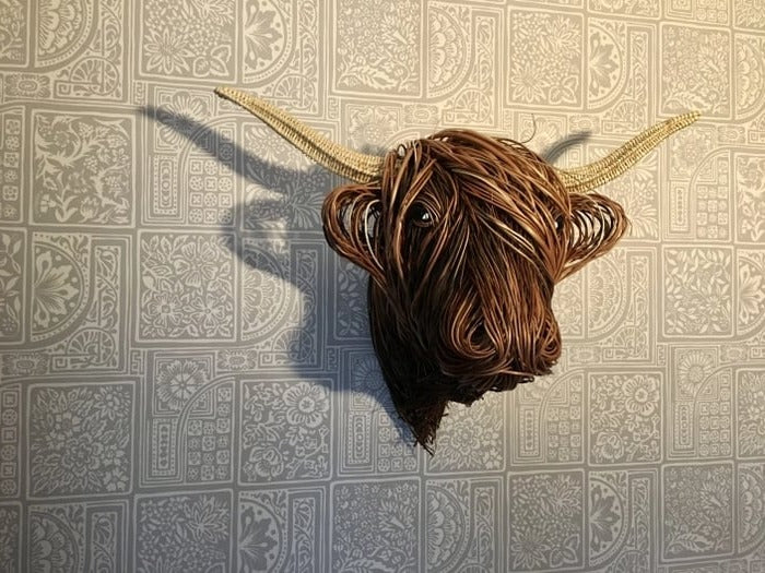 Escultura de vaca montada en la pared